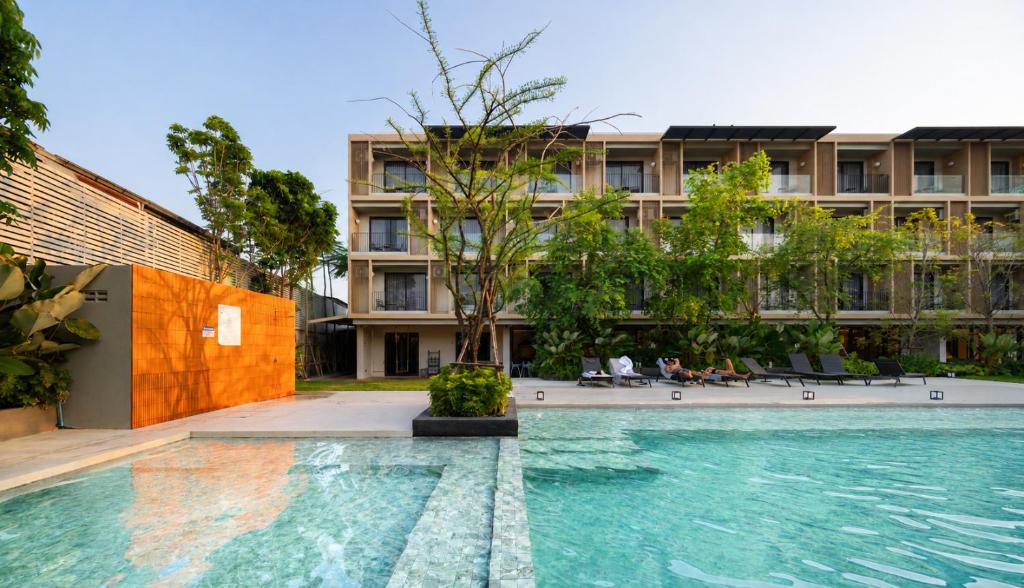 a swimming pool in front of a building at PAAK Hotel Suvarnabhumi in Lat Krabang