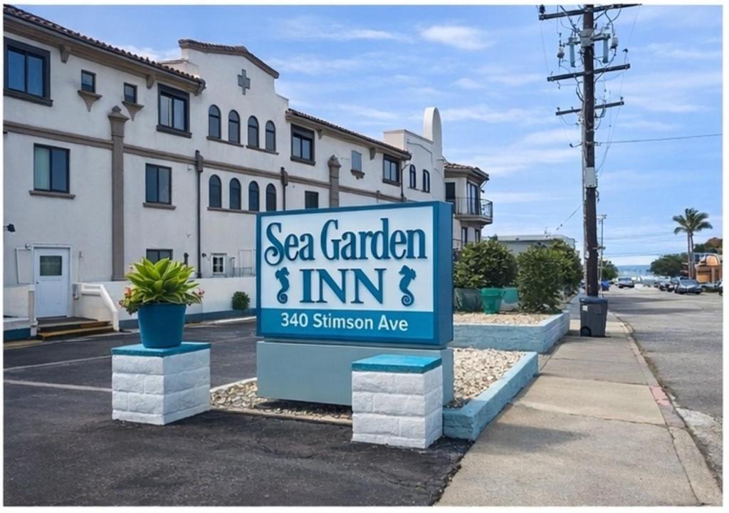 a sign for a sea garden and inn in a parking lot at Sea Garden Inn Pismo Beach- San Luis Obispo in Pismo Beach