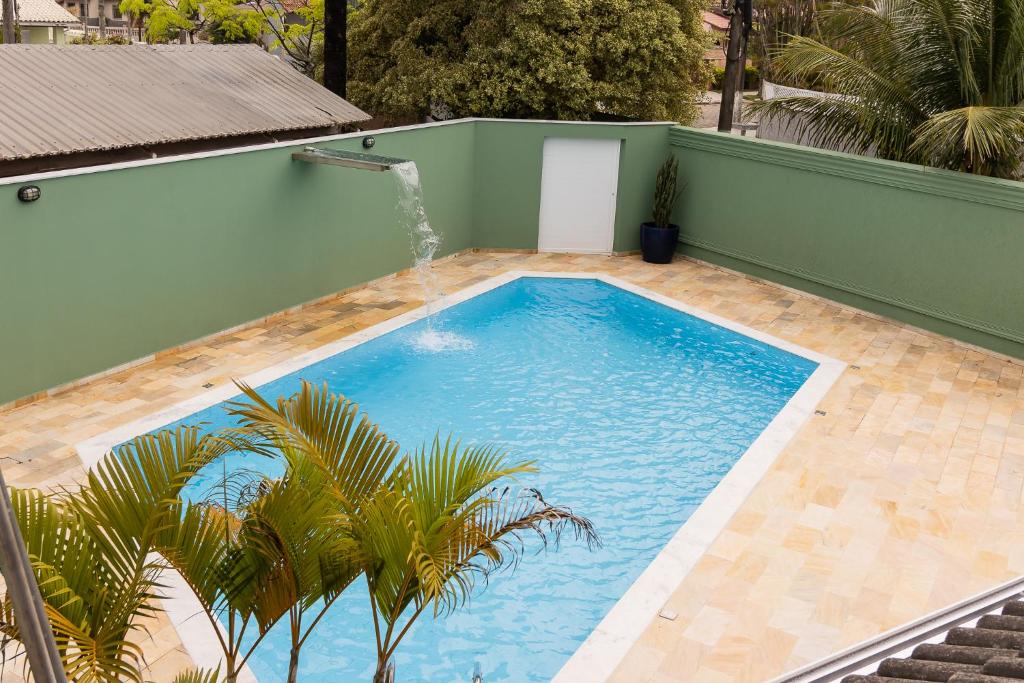 a large blue swimming pool with a fountain at Casa de praia Peruibe in Peruíbe