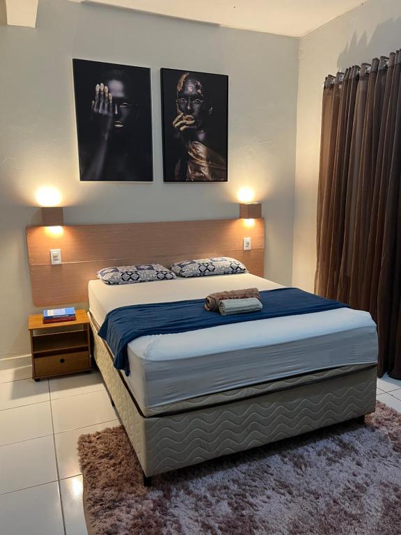 a bedroom with a bed with two pictures on the wall at Casa em Seabra in Seabra