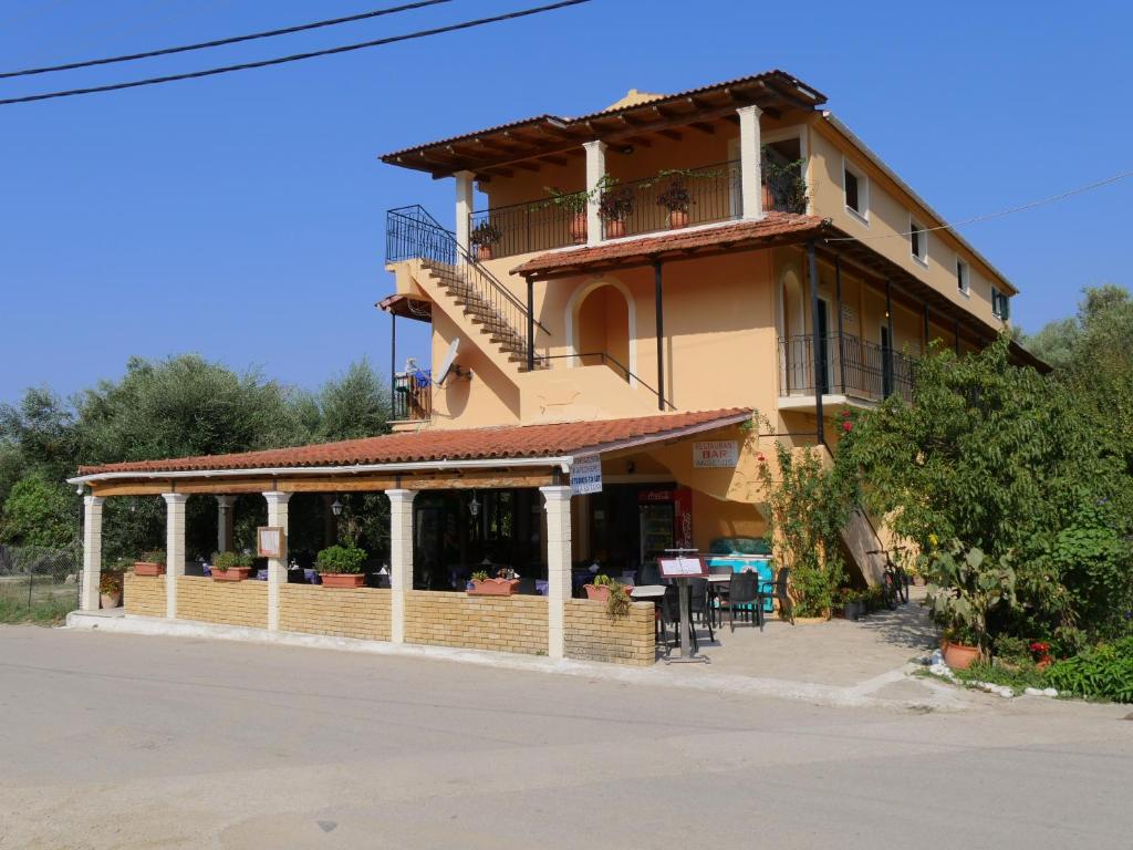 a building with a balcony and a table in front of it at Villa Katerina in Agios Georgios Pagon