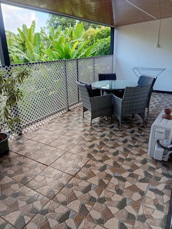 a patio with a table and chairs on a tiled floor at Tereva home 2 in Bora Bora