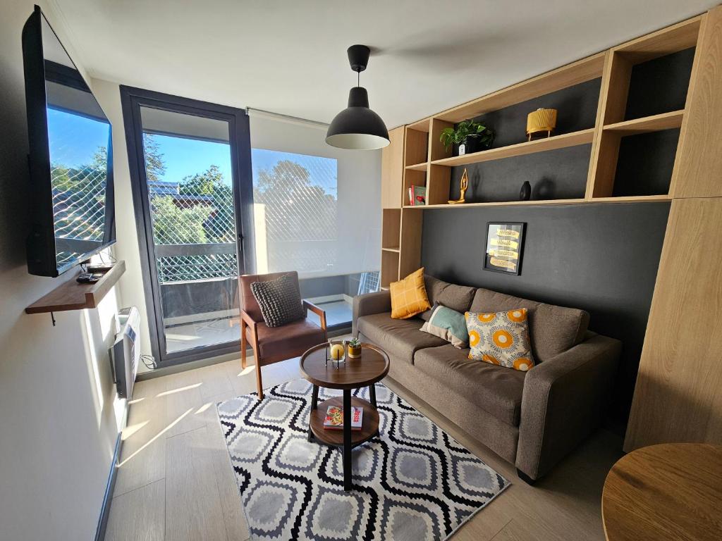 a living room with a couch and a table at Depto con Piscina Temperada 2D y 2B in Puerto Varas