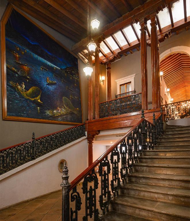 a staircase in a building with a painting on the wall at Hotel Boutique Grand Mayes in Pátzcuaro