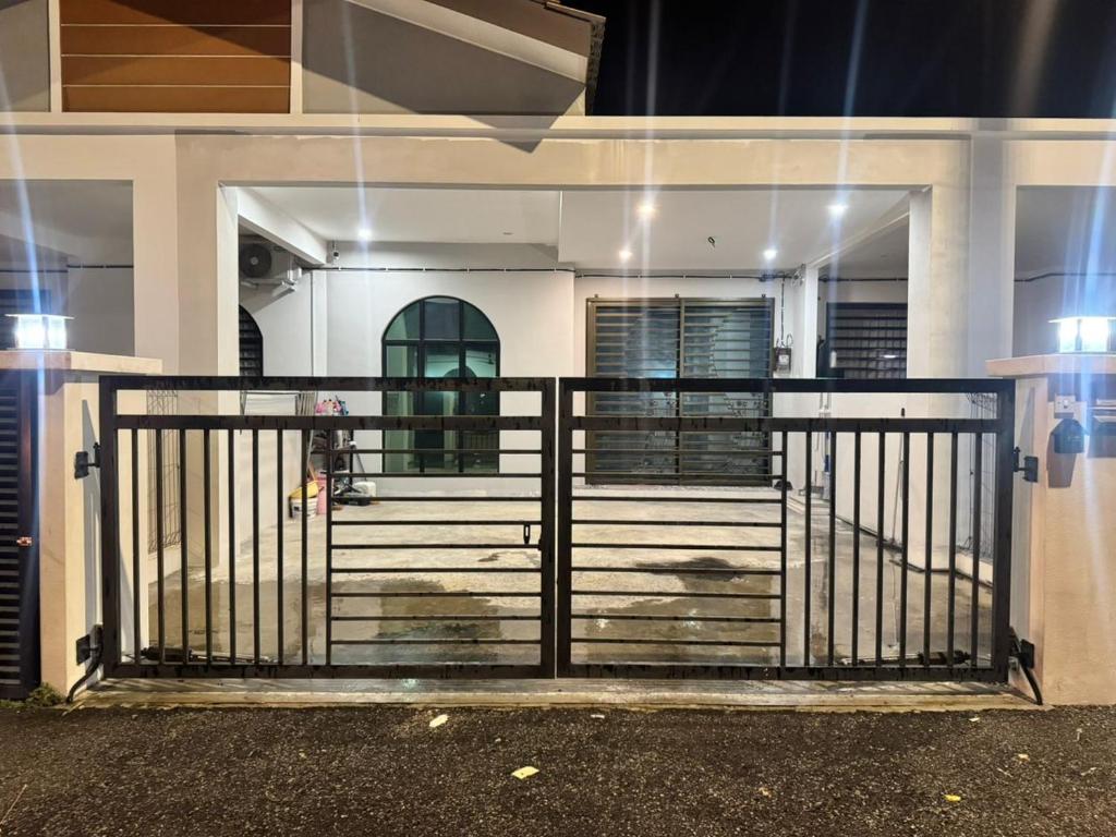 a gate in front of a house at night at Dgajah Homestay in Batu Gajah
