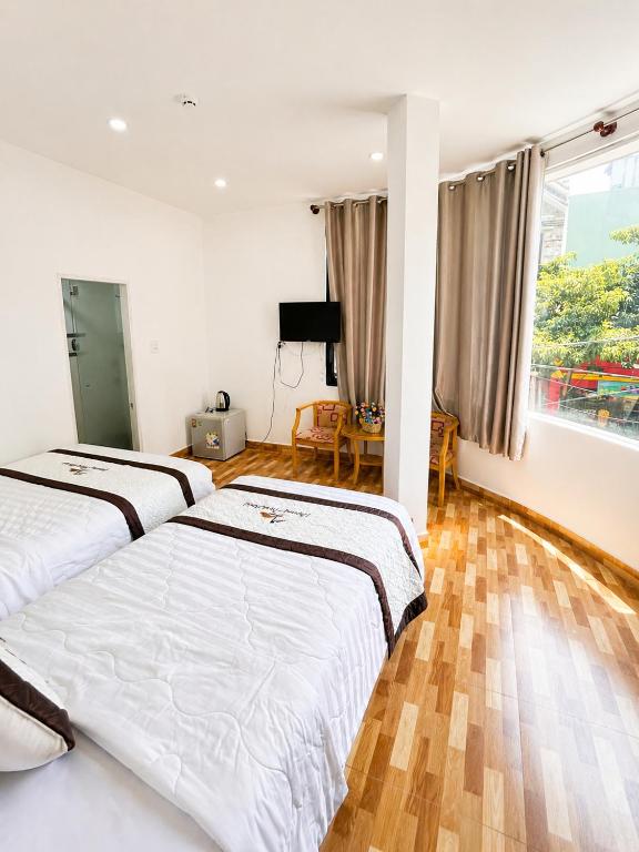a bedroom with two beds and a television at Khách sạn Phương Danh in Phú Tài (1)