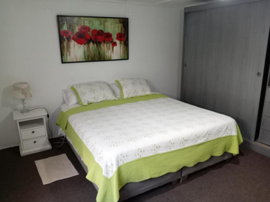 a bedroom with a bed and a painting on the wall at Casa in Santiago