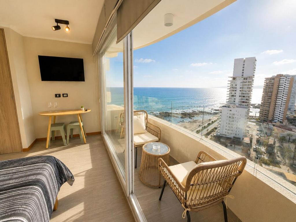a bedroom with a bed and a view of the ocean at Estudio peninsula Cavancha in Iquique