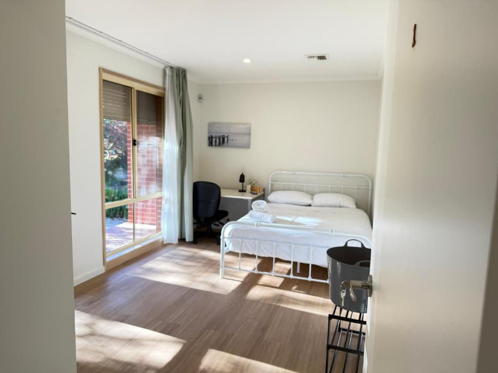 a bedroom with a bed and a desk and a window at Central Private Room - Stroll to ANU & City in Turner