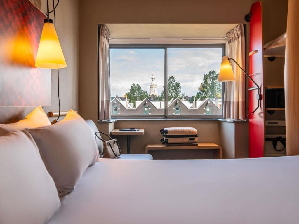 a bedroom with a large bed and a window at ibis Amsterdam Centre Stopera in Amsterdam