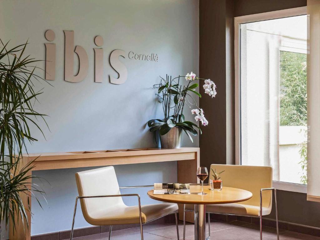 a dining room with a table and two chairs at Ibis Cornella in Cornellà de Llobregat