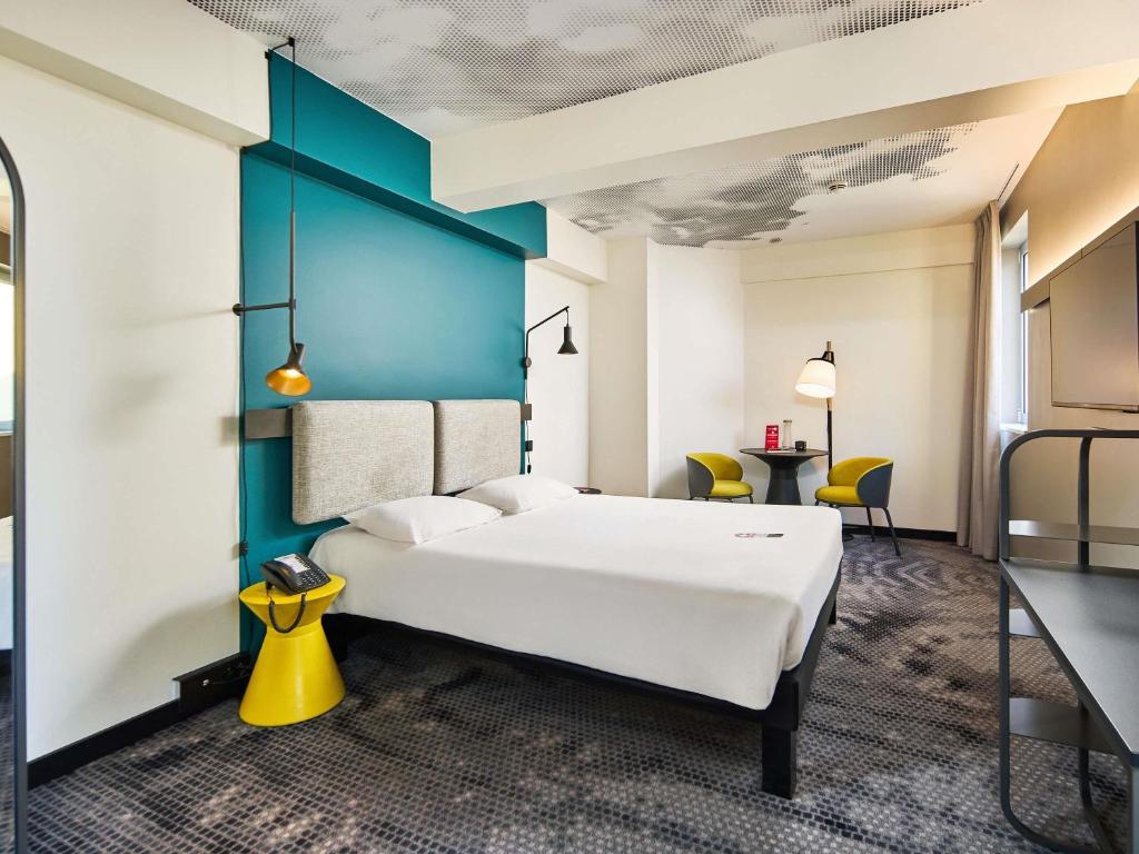 a bedroom with a large white bed and a blue wall at Ibis Praha Wenceslas Square in Prague