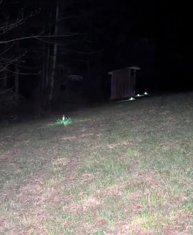 a grassy field with a wooden structure in the dark at Goldenrod Gap in Wellington