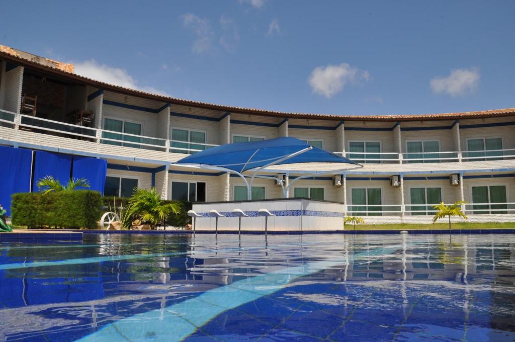 um hotel com piscina em frente a um edifício em Brisa Mar em Flecheiras