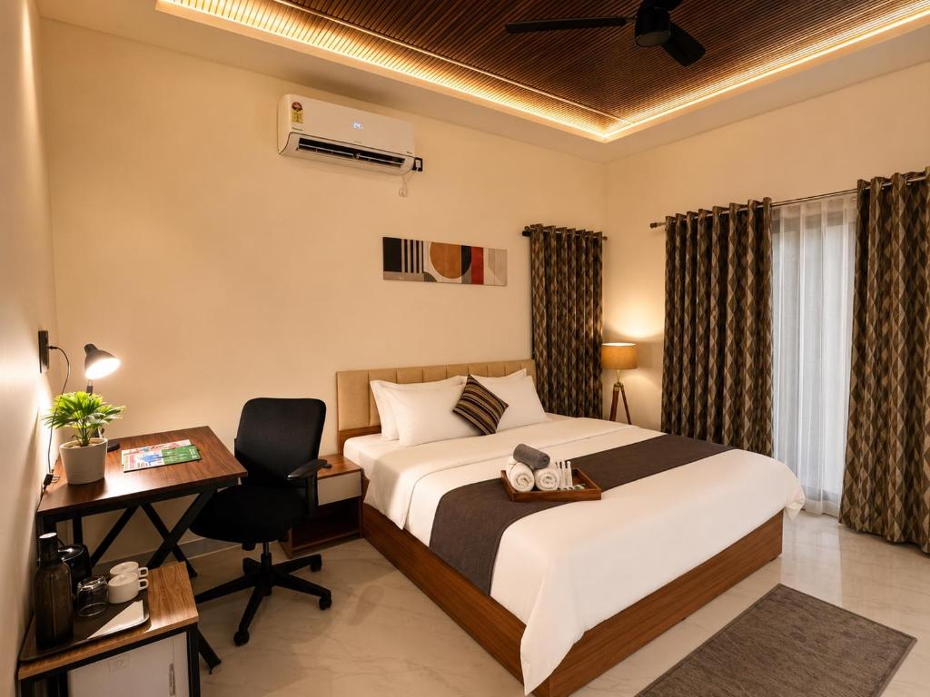 a hotel room with a bed and a desk and a computer at Kalarava private rooms in Chikmagalūr