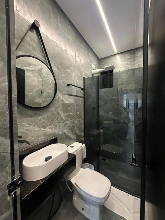 ein Badezimmer mit Toilette und Glasdusche in der Unterkunft Northeast in São Paulo