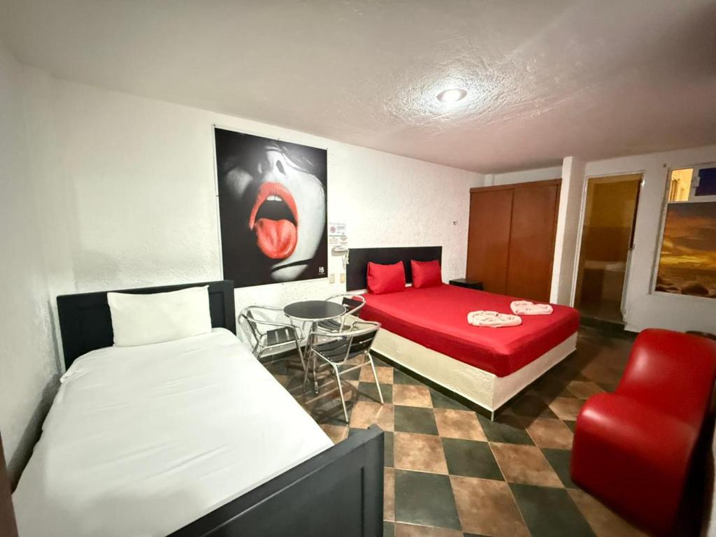 a room with two beds and a table and a chair at Hotel Boppard in Mexico City