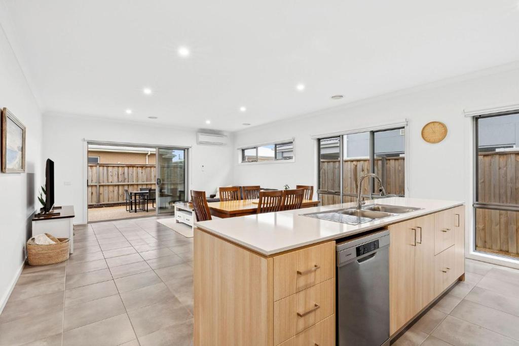 an open kitchen and living room with a table at Point Retreat in Point Lonsdale