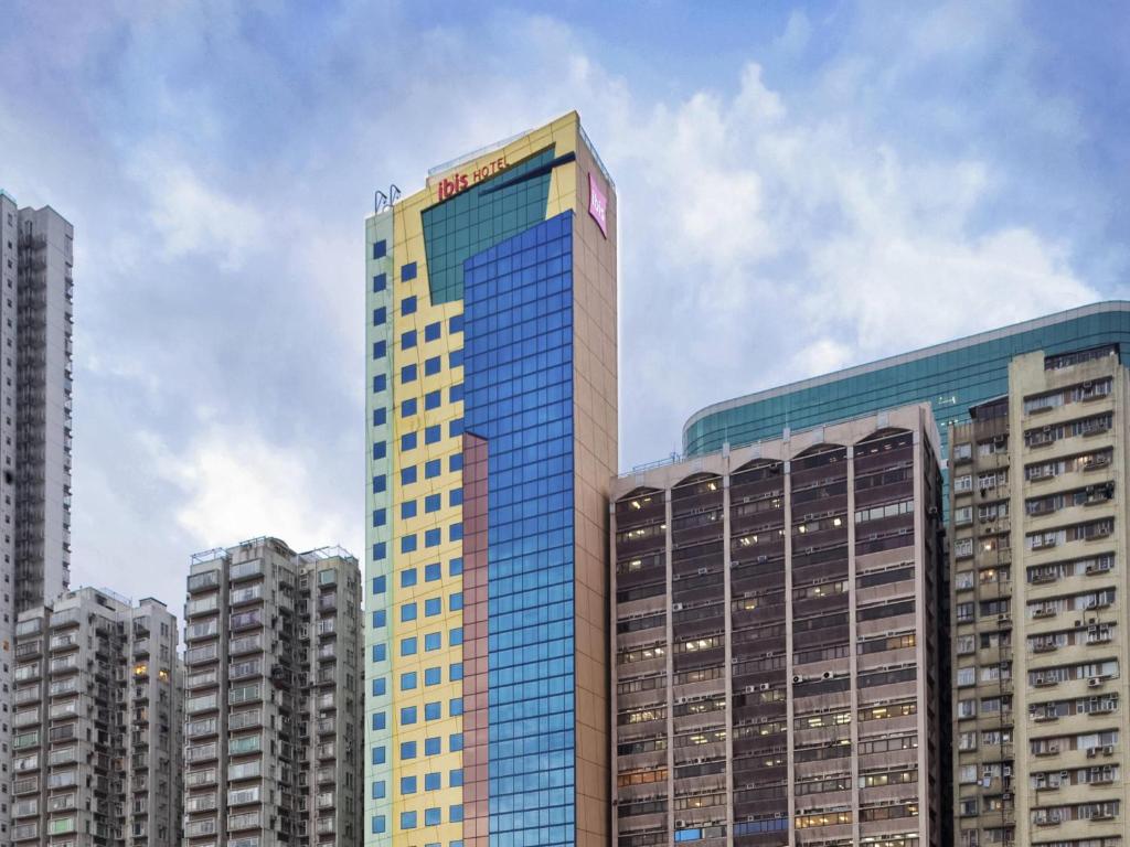 a tall building with a sign on the top of it at ibis Hong Kong North Point in Hong Kong