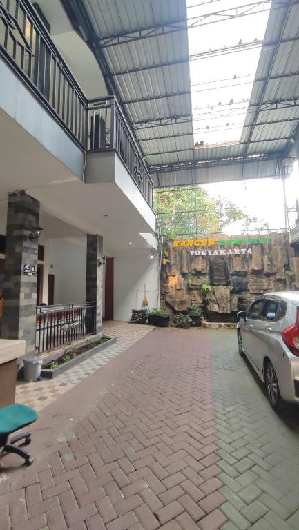 a car parked inside of a building with a rock wall at UnitA 5BR Kangen Homestay Jambon Yogyakarta in Cebongan