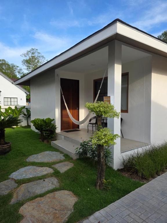 a small white house with a patio and grass at Neramit House in Ko Phangan