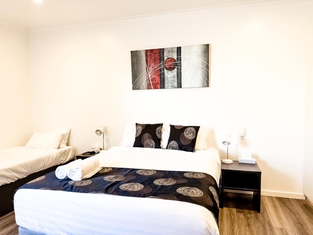 a bedroom with two beds and a picture on the wall at city unit at gouger st in Adelaide
