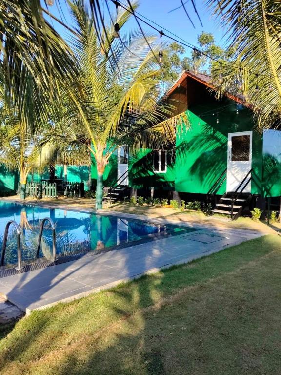 a resort with a swimming pool in front of a building at Chill Hutz in Vedakudiyiruppu