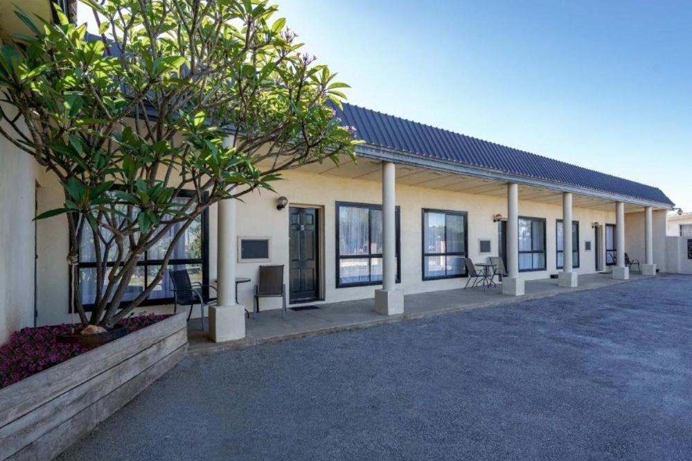 a building with a lot of windows and a tree at Kerang Valley Resort in Kerang