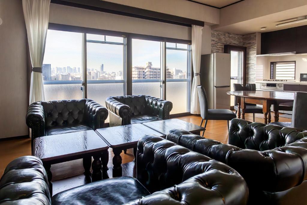 a living room with leather couches and a table at La Pace Awaji in Osaka