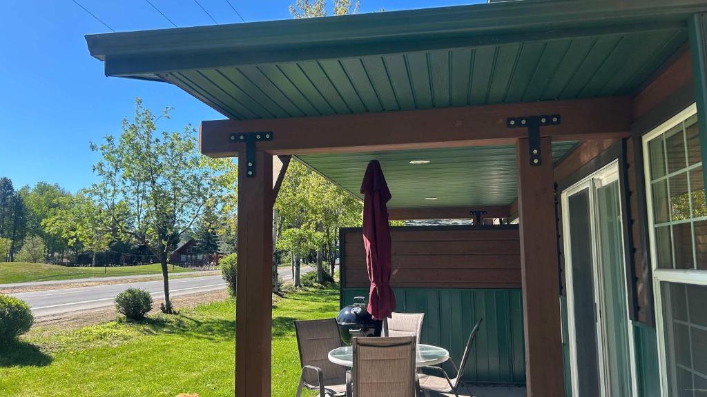 awning over a porch with a table and chairs at Davis Beach Getaway Pet Friendly & Beach Access in McCall