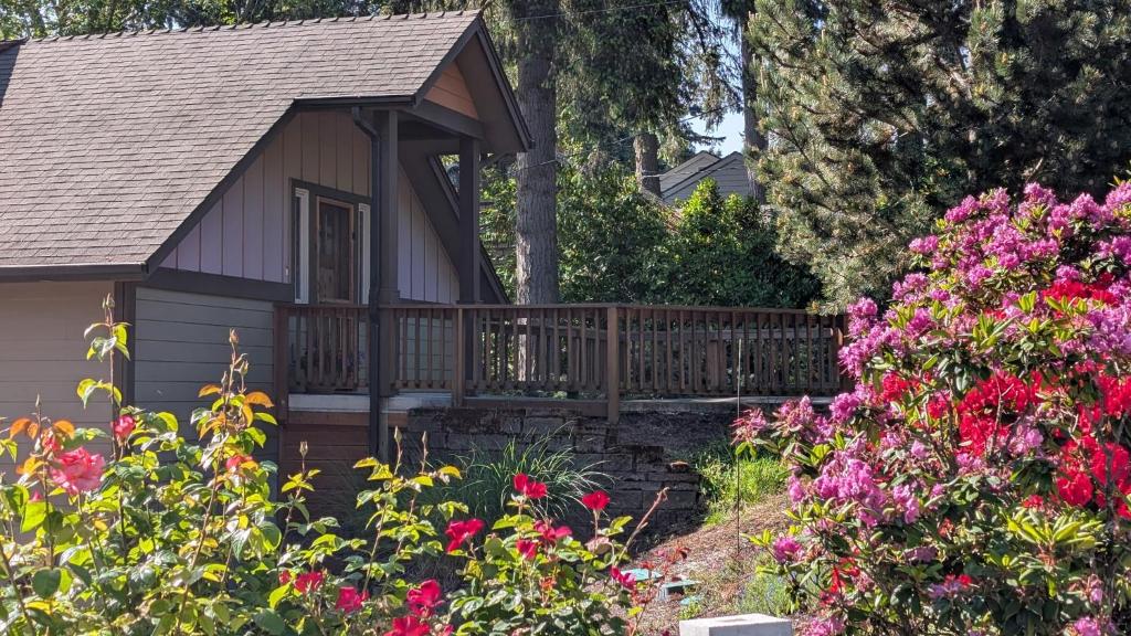 a garden with flowers and a wooden gazebo at Emerald Retreat in Eugene