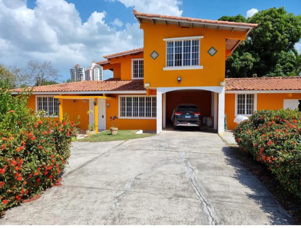 an orange house with a car parked in the driveway at La almeja in Nueva Gorgona