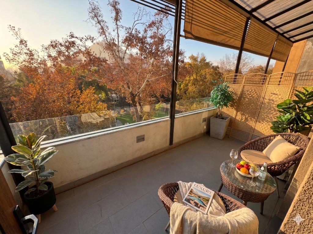 a balcony with a table and chairs and a large window at BHB Hotel Boutique in Santiago