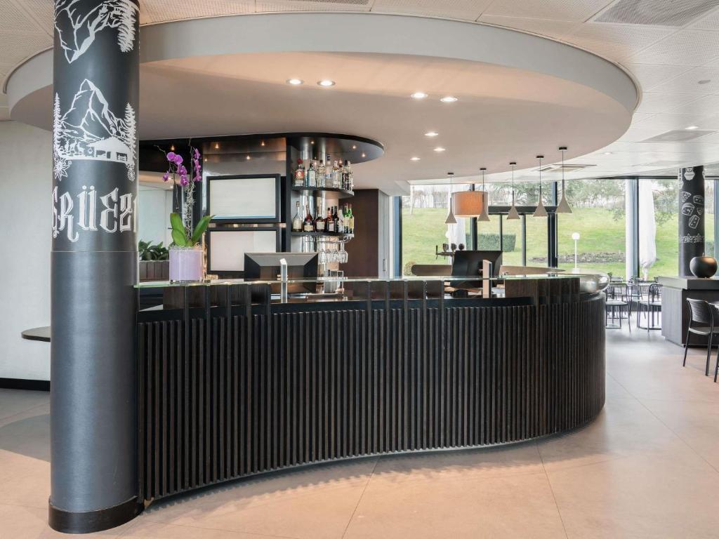 a restaurant with a bar in a building at Novotel Suites Genève Aéroport in Geneva