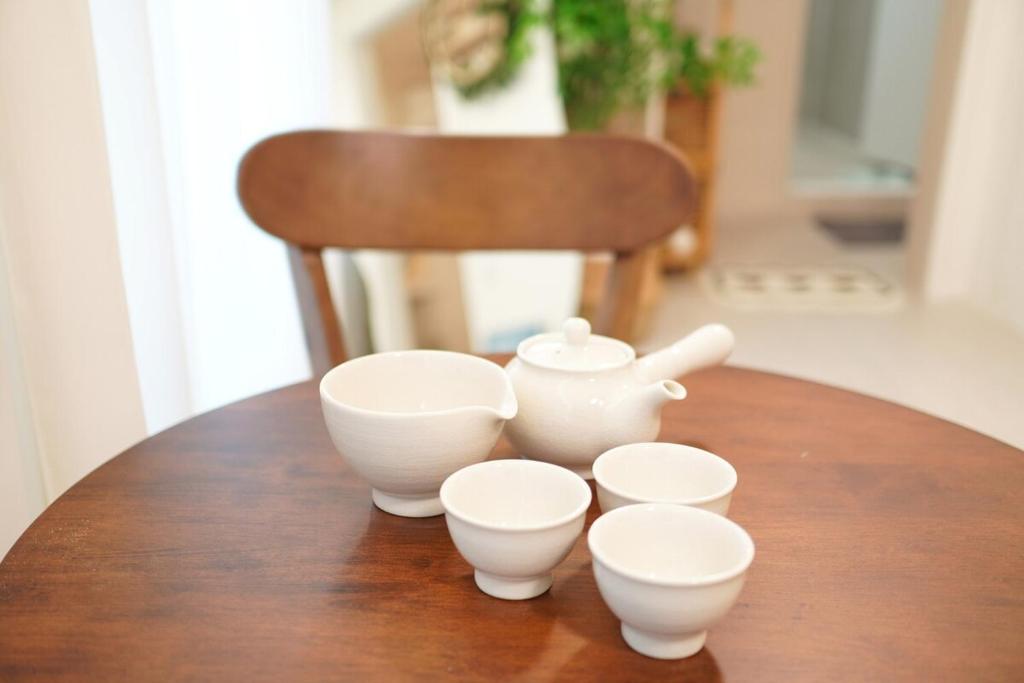 a table with four white bowls and a tea pot at Yeosu1944 in Yŏsu