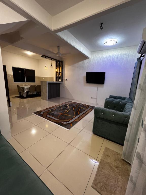 a living room with a couch and a tv at D Alamanda Homestay in Kampong Kapinan