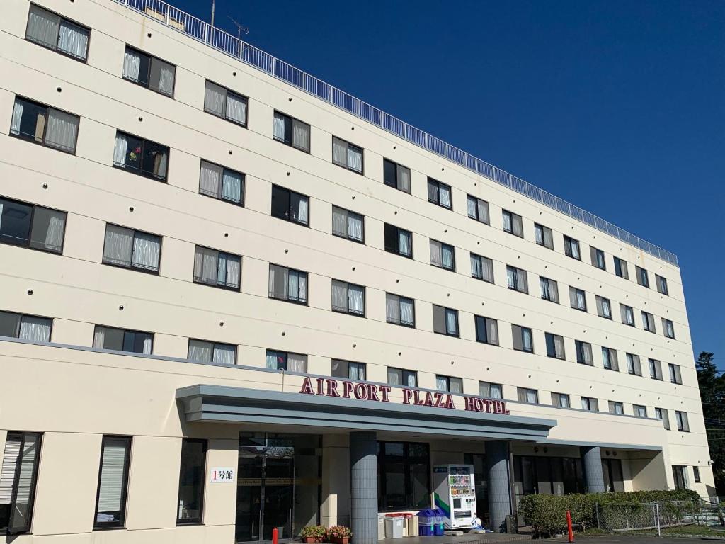 a large white building with an air force trial hotel at Airport Plaza Hotel in Tomisato