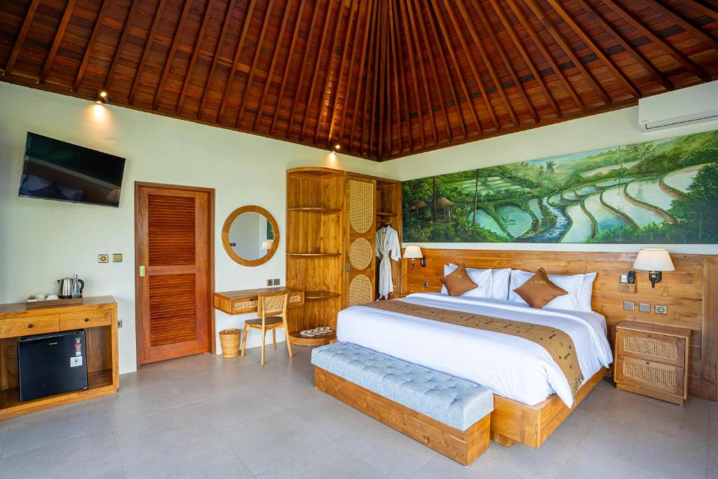 a bedroom with a large bed and a painting on the wall at Gauri Villas Sidemen in Sidemen