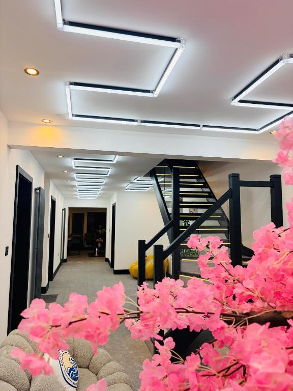 a hallway with pink flowers and a staircase at Bel Casa Solihull in Solihull