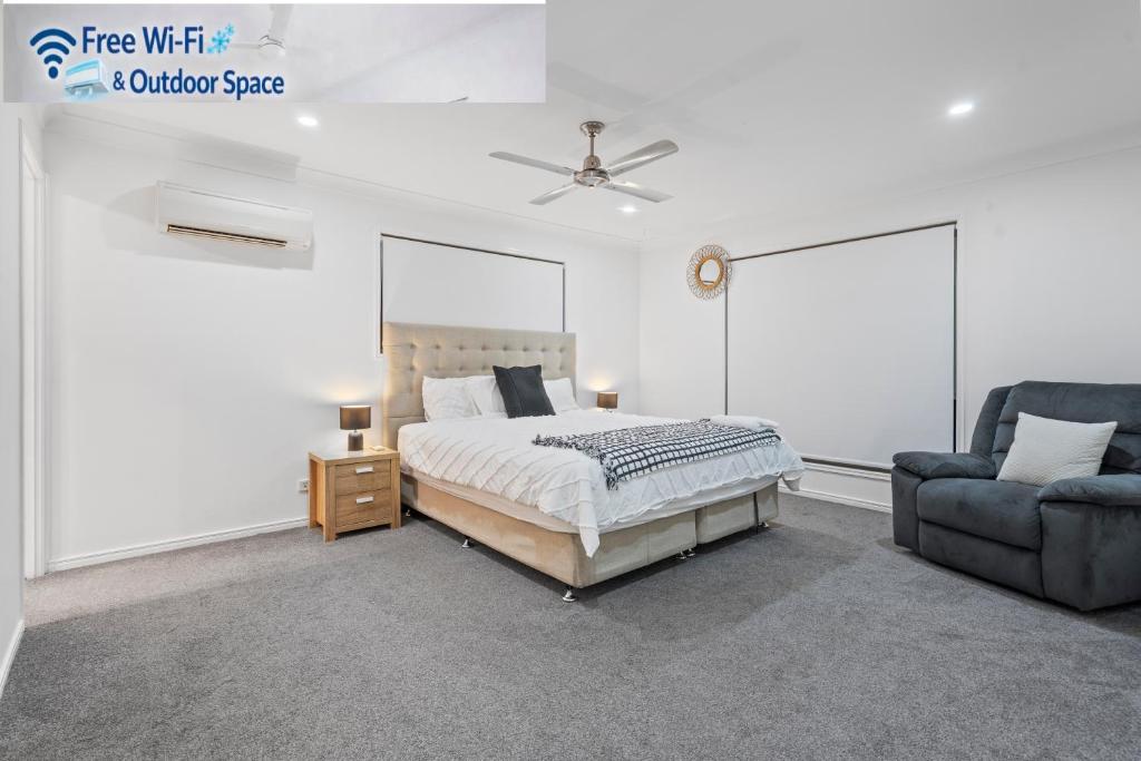 a white bedroom with a bed and a chair at Forest view guesthouse in Runcorn