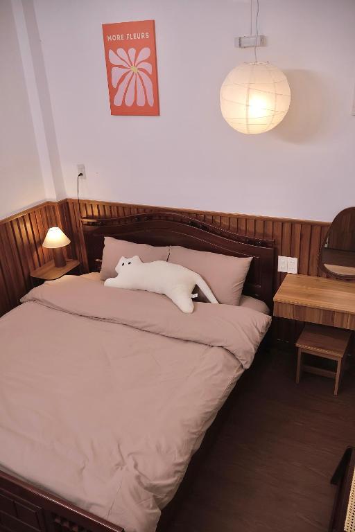 a bed with a white cat laying on top of it at Mộng Homestay in Huế in Thôn Trường Giang