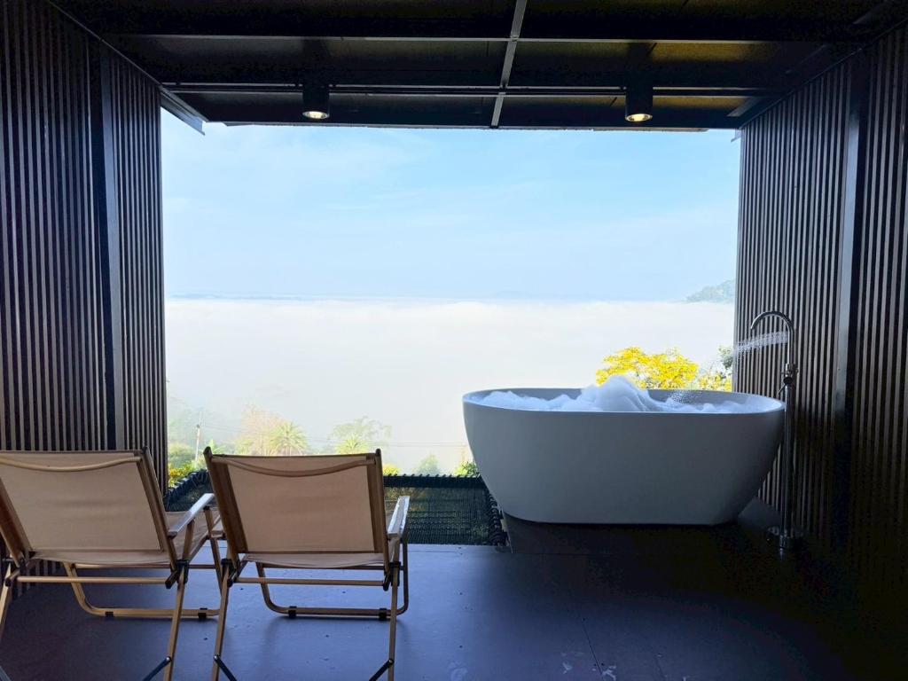 a bathroom with two chairs and a bath tub at Heaven Khaokho2 in Khao Kho