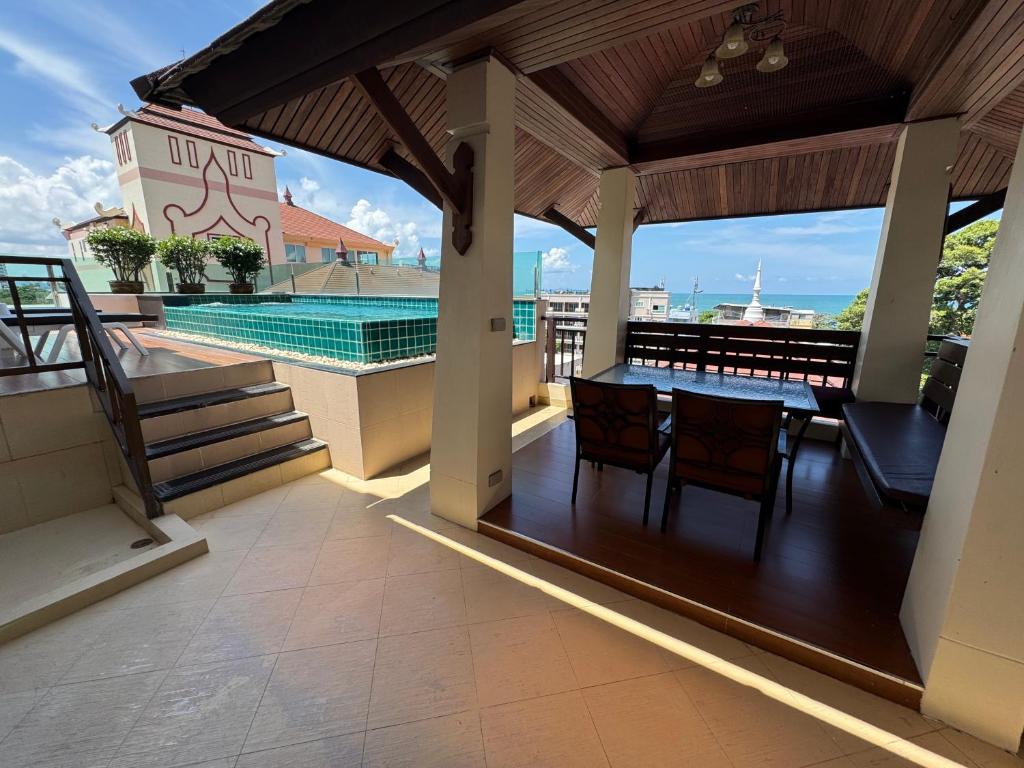 a balcony with a table and a swimming pool at Jomtien Beach Penthouses in Jomtien Beach
