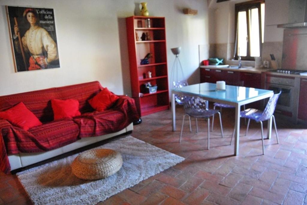 a living room with a red couch and a table at SienaHomeAndSailing 2 in Siena