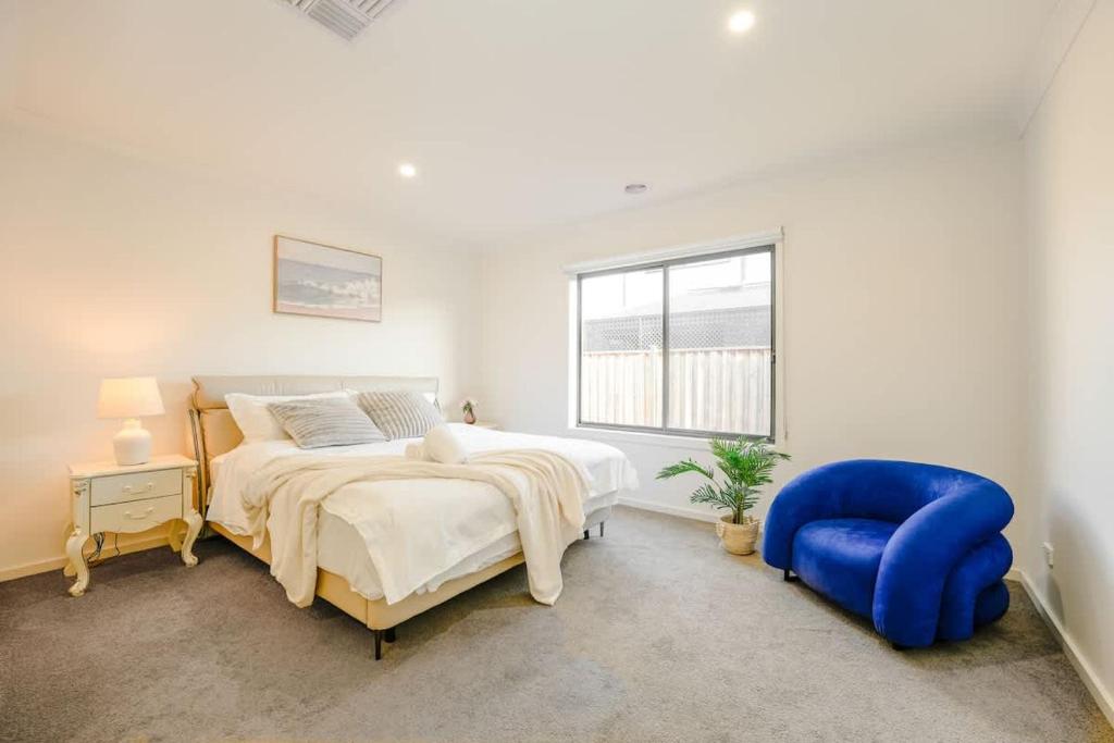 a bedroom with a bed and a blue chair at Seednest Stylish & Perfect for Relaxation in Melton South