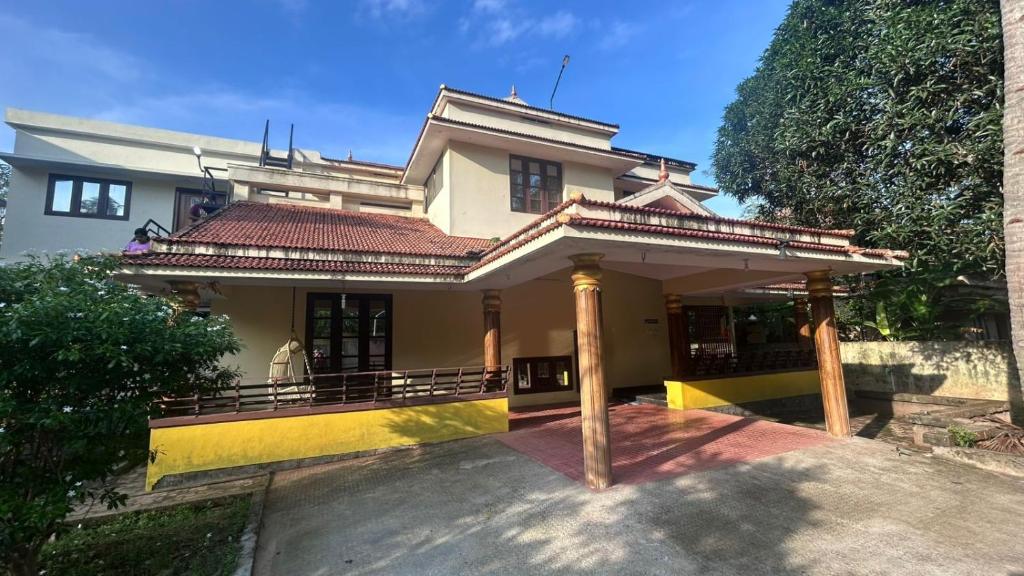 a house with a yellow and white building at Dream Stay in Varkala