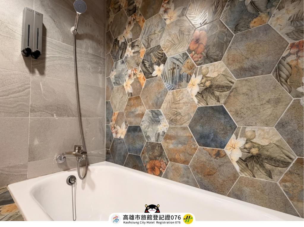a bath tub in a bathroom with a tiled wall at I HI Sanduo Travel Hotel in Kaohsiung