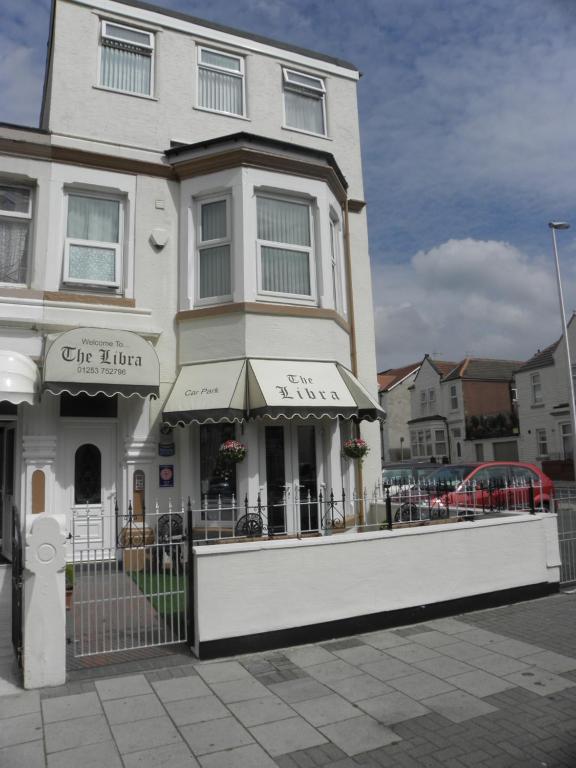 um edifício branco com uma cerca em frente em The Libra em Blackpool