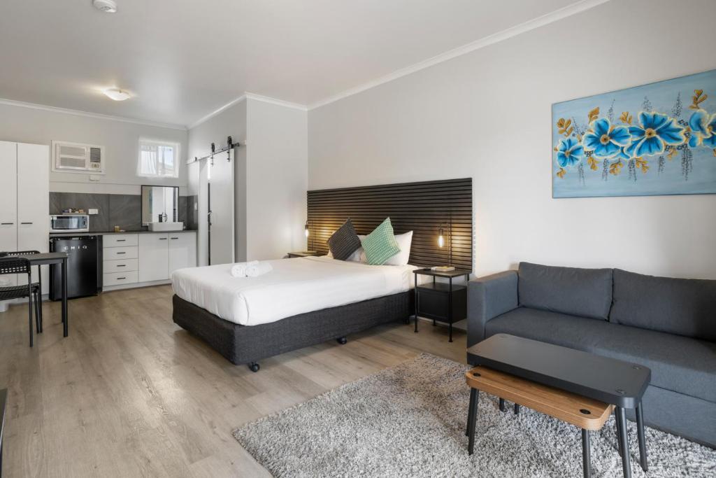 a bedroom with a bed and a couch at Carrum Downs Motel in Carrum Downs