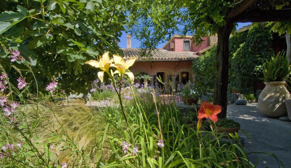 a garden with flowers in front of a house at Hotel Lucrezia in Riola Sardo